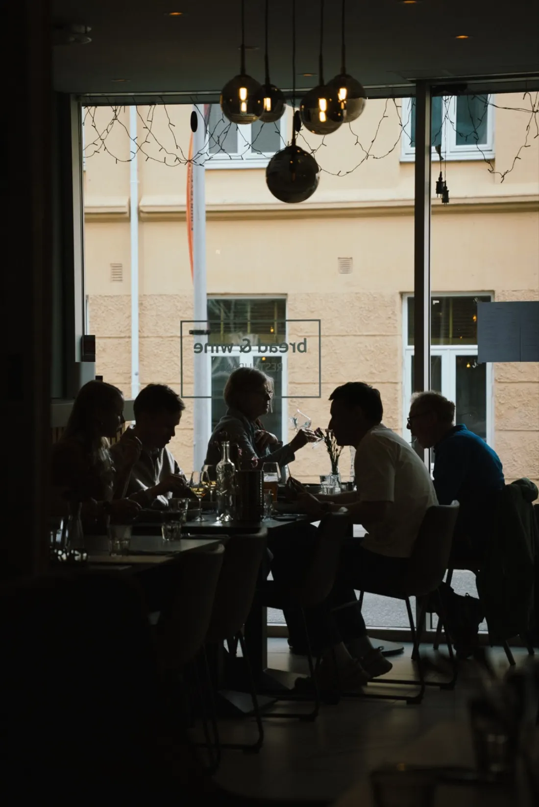 Guests dining by the window at Bread & Wine